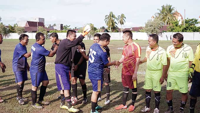 Bupati Rohil Afrizal Sintong SIP dan Wabup H Sulaiman SS MH bersalaman pada saat bersama-sama bermain sepakbola legenda yang digelar di lapangan KONI, Bagansiapiapi, baru-baru ini.