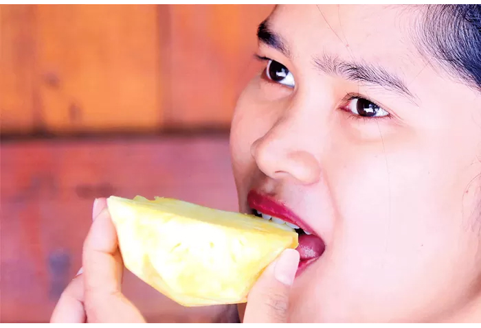 Devi mengonsumsi buah nanas untuk menjaga kesehatan.