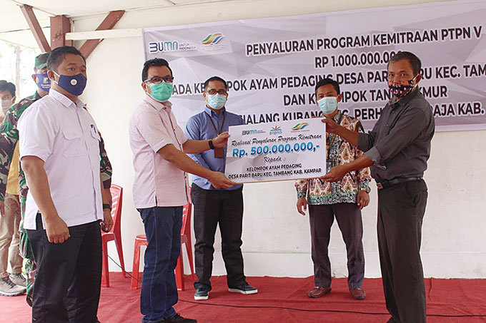 Ketua Kelompok Peternak Ayam Pedaging di Kecamatan Tambang Kampar Akbar Markib mewakili rekan-rekannyaÂ menerima bantuan pendanaan UMK dari PTPN V yang diserahkan secara simbolis oleh SEVP Business Support PTPN V Rurianto di Kebun Sei Pagar PTPN V, Selasa