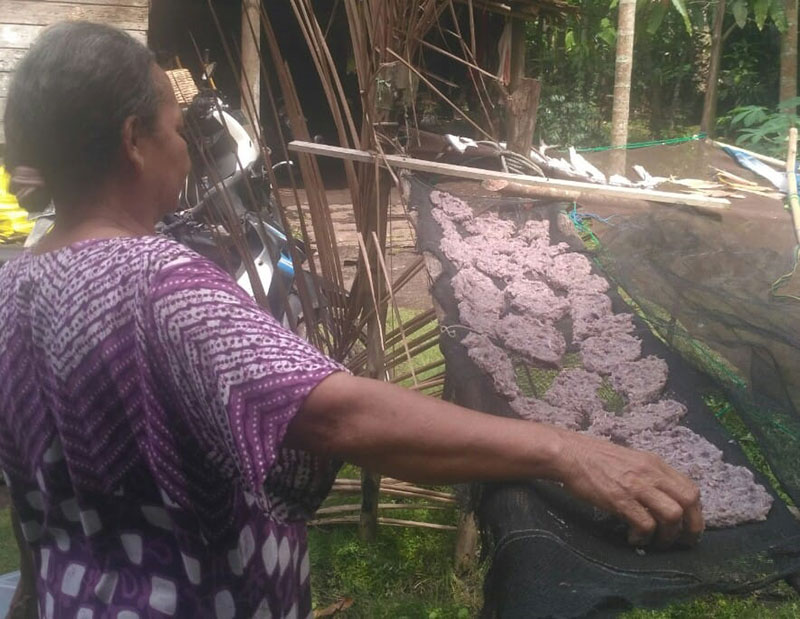 Seorang ibu melakukan penjemuran udang bubuk di Bengkalis. (ERWANSANI/RIAUPOS.CO)