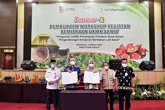 Direktur Utama Bank Riau Kepri Andi Buchari (dua kiri) dan Ketua Asosiasi Samade DPW Riau Karmila Sari (tiga kanan) memperlihatkan PKS yang telah diteken di Hotel Grand Central Pekanbaru, Rabu (23/3/2022).