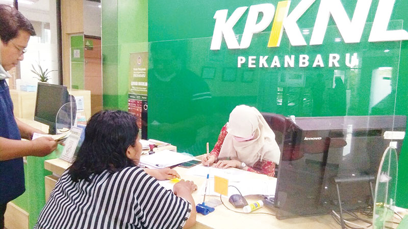 Karyawan KPKNL Pekanbaru memberikan pelayanan kepada masyarakat yang datang ke kantor KPKNL Pekanbaru di Jalan Jenderal Sudirman, Selasa (6/10/2020).(MUJAWAROH ANNAFI/RIAUPOS.CO)