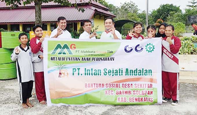 Manajemen PKS PT ISA foto bersama para pelajar SMPN 10, Desa Bumbung  usai menyerahkan bantuan sembako untuk masyarakat dan 15  tong sampah untuk SMPN 10,  Desa Bumbung, Kecamatan Bathin Solapan, baru-baru ini.