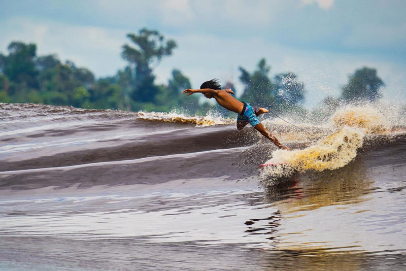 Peselancar tengah menikmati berselancar di Ombak Bono, Pelalawan.
