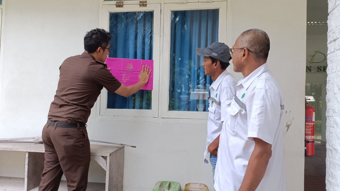 Kasi Pidsus Kejaksaan Negeri (Kejari) Kampar Amri Rahmanto Sayekti memasang stiker penyitaan terhadap PT Johan Sentosa di lingkungan Sungai Jernih, Kelurahan Pasir Sialang, Kecamatan Bangkinang, Kabupaten Kampar, Senin (9/1/2023).
