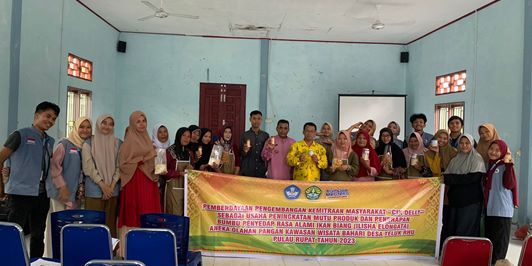 Ketua Pengabdian: Dr Sumarto SPi MSi (baju batik kuning); Kepala Desa Mansur (baju Melayu Merah Muda) Bersama masyarakat dan Mitra UMKM Cik Delly.