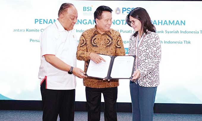 Direktur Utama PT Bank Syariah Indonesia Tbk (BSI) Hery Gunardi (tengah) berbincang dengan Ketua Umum KONI Pusat Letnan Jenderal TNI (Purn) Marciano Norman (kiri) dan Wakil Ketua Umum II PSSIÂ  Ratu Tisha Destria (kanan) di sela penandatanganan nota kesep
