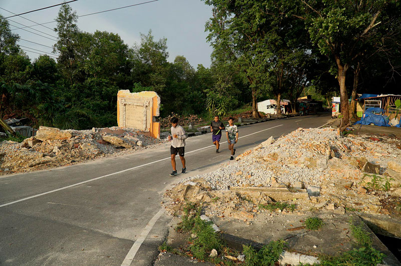 Sejumlah warga melintas di dekat gapura Taman Labuai dekat Bandar Serai Raja Ali Haji (Purna MTQ) telah dirobohkan dan diratakan, Senin (28/8/2023). Gapura dirobohkan karena kondisinya yang sudah miring dan retak-retak.