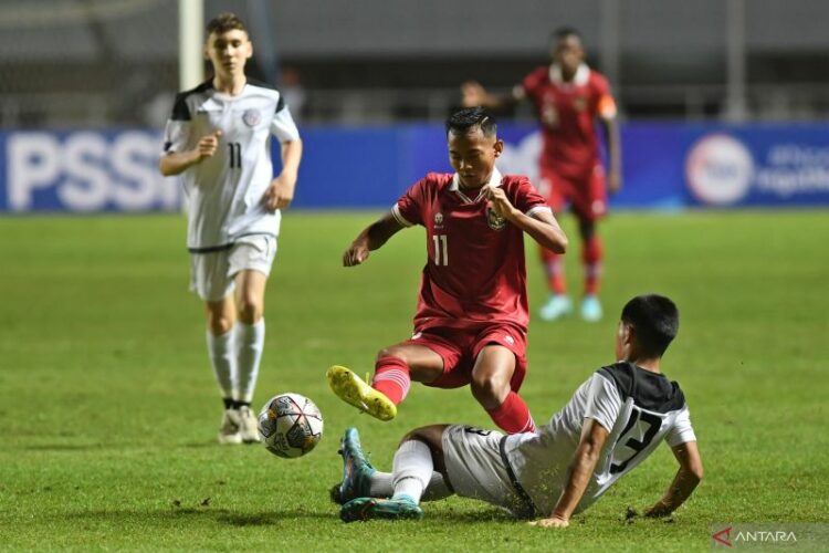 Pemain Timnas U-17 Indonesia Riski Afrisal (atas) berebut bola dengan pemain Guam U-17 Nicholas Moore (bawah) dalam laga Grup B Kualifikasi Piala Asia U-17 2023 di Stadion Pakansari, Cibinong, Kabupaten Bogor, Jawa Barat, Senin (3/10/2022).