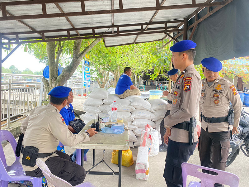 Personel Ditpolairud Polda Riau saat memberikan edukasi pemilu damai kepada masyarakat yang tinggal di pelabuhan, Jumat (22/12/2023).