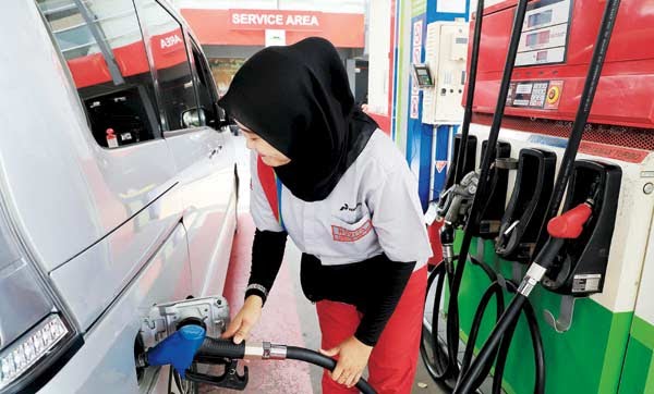 Seorang petugas SPBU sedang mengisi bahan bakar.