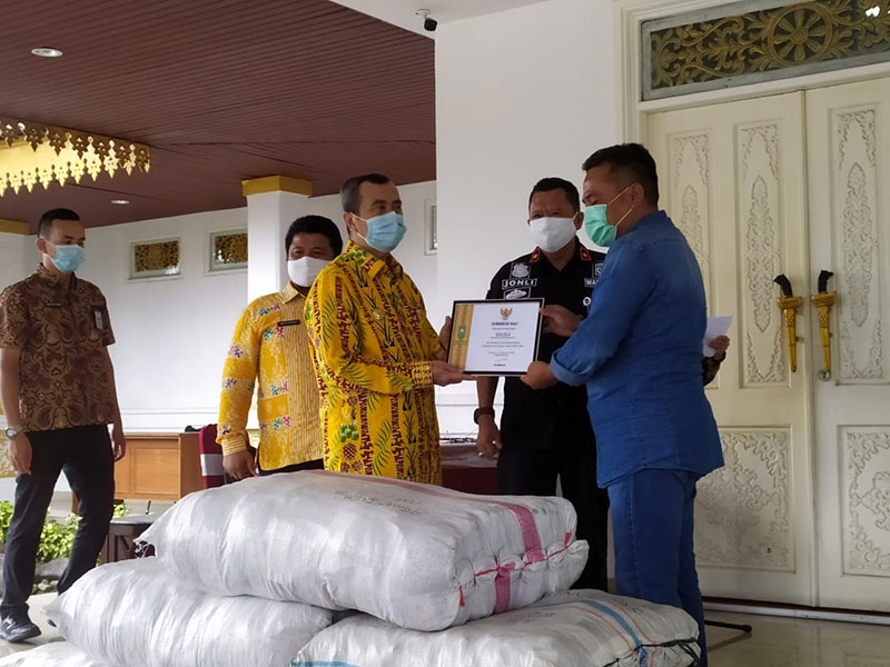 Humas PT Musim Mas Ibrahim menyerahkan bantuan 30 ribu masker kepada Gubri Drs H Syamsuar MSi, Kamis (1/10) sore. (ISTIMEWA)