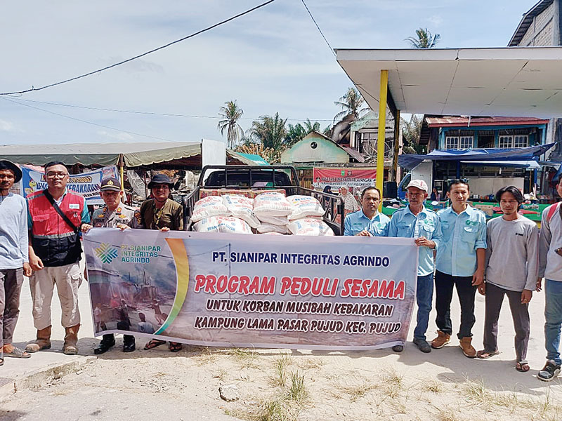 Manajer PT Sianipar Integritas Agrindo Rony Ahmadi didampingi staf perusahaan foto bersama dengan Kapolsek Pujud AKP Tri Adityamika SH saat penyerahan bantuan bagi warga yang mengalami musibah kebakaran di Kelurahan Pujud Selatan, Kecamatan Pujud, Rokan H