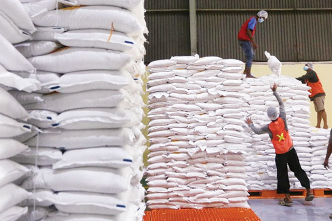 Para buruh mengangkat karung beras  di gudang  RTT Bulog Kelapa Gading, Jakarta, baru-baru ini.