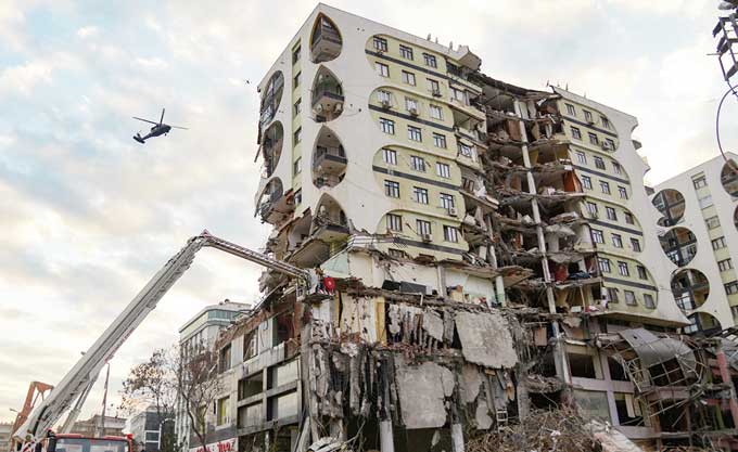 Helikopter terbang di atas bangunan rusak akibat gempa di Diyarbakir, Turki Tenggara, pekan lalu.