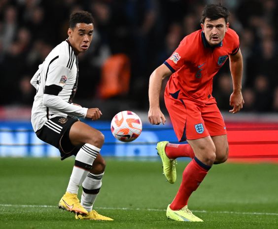 Gelandang serang Jerman Jamal Musiala (kiri) berebut bola dengan bek Inggris Harry Maguire dalam matchday pemungkas grup 3 UEFA Nations League A di Wembley Stadium kemarin (27/9) dini hari WIB.