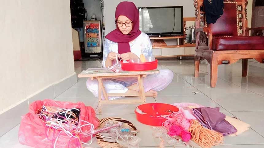 Adisty sedang membuat konektor masker yang diproduksinya menggunakan bahan limbah manik-manik bekas dan kain perca, Sabtu (9/10/2021).