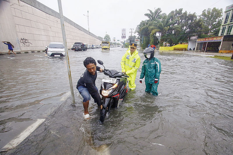 Kapolresta Pekanbaru Kombes Pol Jefri Siagian membantu warga yang kendaraannya mogok akibat banjir di Jalan Soekarno-Hatta, Pekanbaru, Rabu (6/9/2023).