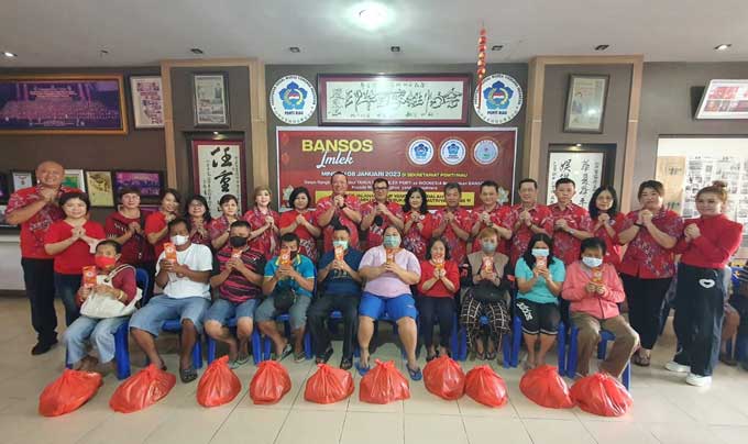 Pengurus PSMTI Riau, PSMTI Pekanbaru, dan Perwanti foto bersama dengan warga Tionghoa usai menyerahkan paket Imlek di Sekretariat PSMTI Riau, Jalan Setia Budi, Kecamatan Limapuluh, Ahad (8/1/2023).