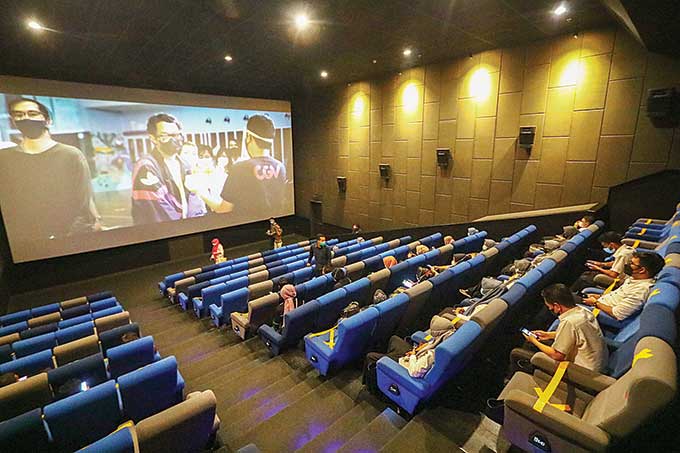 Pengunjung menonton film di bioskop CGV Transmart Pekanbaru,  Rabu (31/3/2021). CGV Transmart Pekanbaru menerapkan protokol kesehatan.