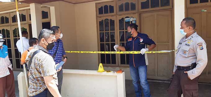 Petugas kepolisian dari Polsek Bukit Raya memasang garis polisi di lokasi penemuan mayat di rumah kontrakan Jalan Kereta Api, Rabu (18/5/2022).