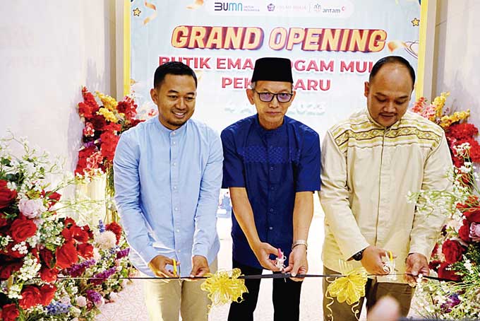 General Manager Logam Mulia Bisnis Unit PT Antam Tbk UBPP Logam Mulia Purwanto (tengah), Senior Manager Sales & Marketing  Yudi Hermansyah, Digital Trading Retail Region I Manager  Ganjar Sulastomo (kanan) memotong pita tanda dibukanya Butik Emas Pekanbar