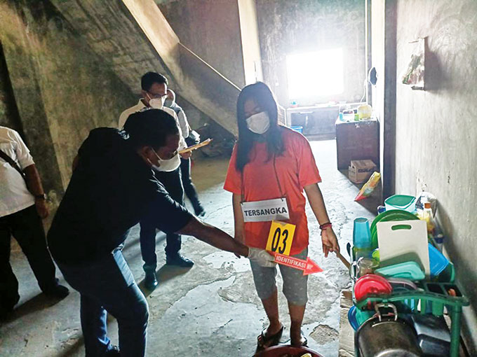 Tersangka ES dan petugas Polresta Pekanbaru saat rekonstruksi di toserba Jalan Darma Bakti, Kecamatan Payung Sekaki, Senin (22/8/2022).