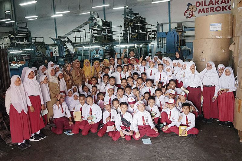 Murid kelas 6 dari SDN 024 Tanah Merah, Kampar didampingi guru berfoto bersama di mesin cetak ketika belajar jurnalistik di Riau Pos,  Selasa (24/10/2023).