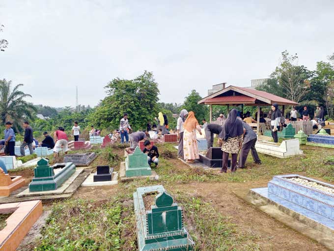 Warga Kelurahan Sungai Jering, Kecamatan Kuantan Tengah saat membersihkan kuburan, Ahad (19/3/2023). Tradisi ini biasanya dilaksanakan sebelum bulan suci Ramadan