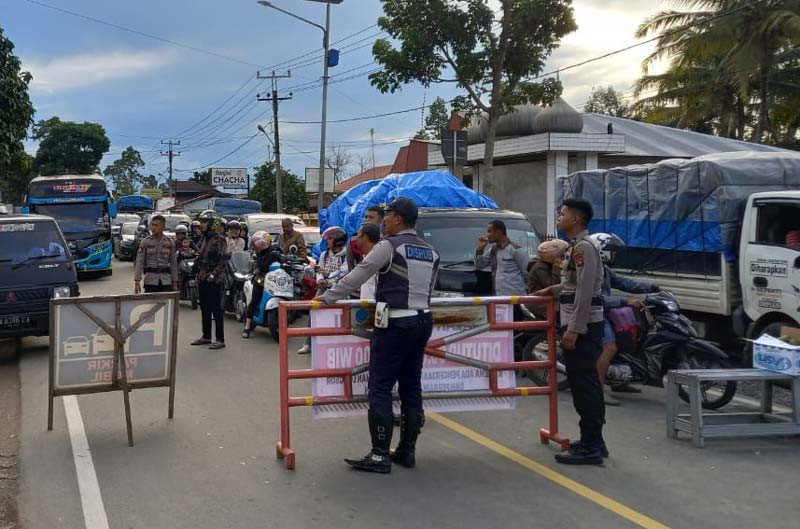 Petugas dari kepolisian dan dinas perhubungan mengatur lalu lintas di Ketinggian, Sarilamak, Kecamatan Harau, Kabupaten Limapuluh Kota, Provinsi Sumatera Barat, Kamis (28/12/2023). Jalan Lintas Riau-Sumbar saat ini sudah Lancar, tapi pengendara tetap hati