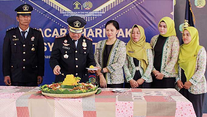 Kepala Rutan Rengat Julius Barus SE MH didampingi istri, memotong nasi tumpeng sebagai simbol syukur, usai mengikuti upacara HBP ke-59, Selasa (2/5/2023).