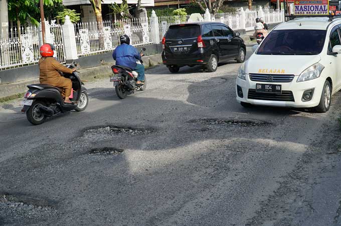 Kondisi Jalan Ahmad Dahlan, Kecamatan Sukajadi yang berlubang, Senin (26/6/2023). Banyaknya lubang menyebabkan pengendara kendaraan bermotor harus berhati-hati saat melewati jalan  ini.