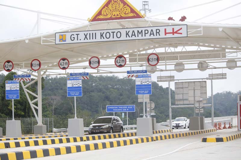 Beberapa mobil pribadi melintas keluar melewati Gerbang Tol XIII Koto Kampar saat dibuka, Ahad (24/12/2023). Pintu masuk dari XIII Koto Kampar akan dibuka saat arus balik pada 1-3 Januari 2024.