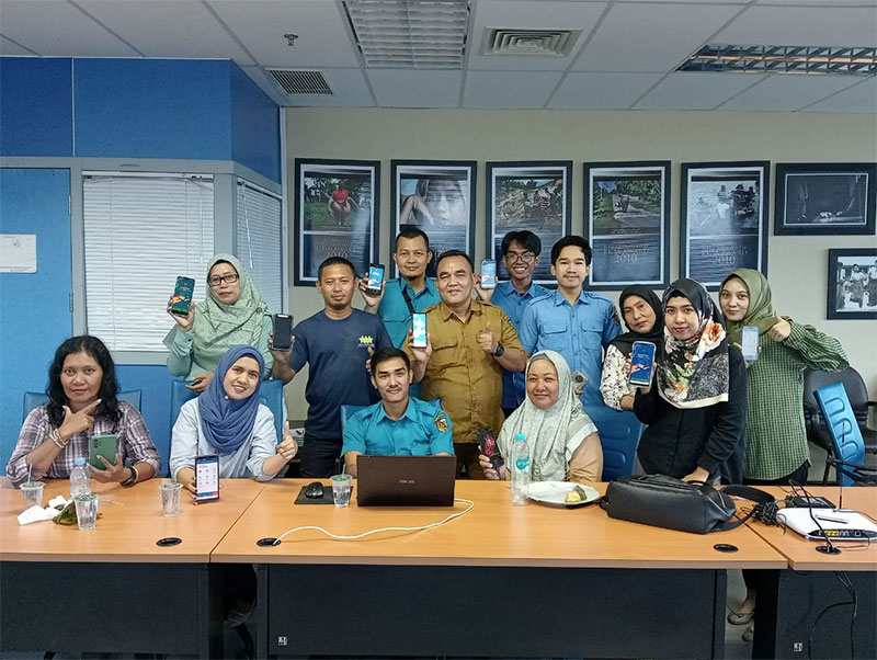 Staf Fungsional Disdukcapil Pekanbaru Darmawan Putra S Kom (baju cokelat) foto bersama karyawan Riau Pos usai melakukan registrasi Identitas Kependudukan Digital (IKD) di Gedung Graha Pena, Selasa (31/10/2023).