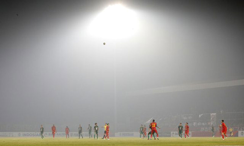 Asap tebal menyelimuti Stadion Tuah Pahoe, Palangka Raya, saat pertandingan Liga 1 2019 antara Kalteng Putra melawan Persebaya, kemarin (13/9). (ANGGER BONDAN/JAWA POS)