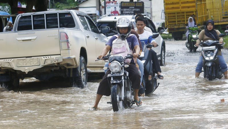 Pengendara kesulitan saat melewati genangan air di Jalan Cipta Karya yang belum surut, Rabu (13/12/2023) siang. Air merendam Jalan Cipta Karya saat hujan deras turun, Selasa (12/12/2023) sore.