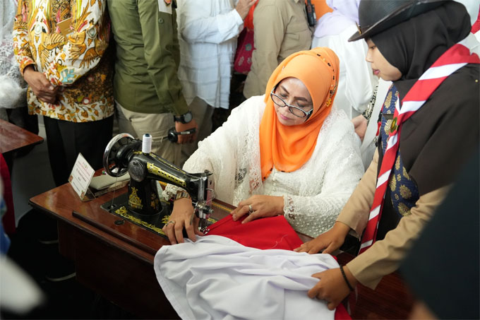 Ketua TP PKK Riau Misnarni Syamsuar menjahit bendera merah putih pada peringatan Hari Ibu di Bengkulu, Rabu (21/12/2022).