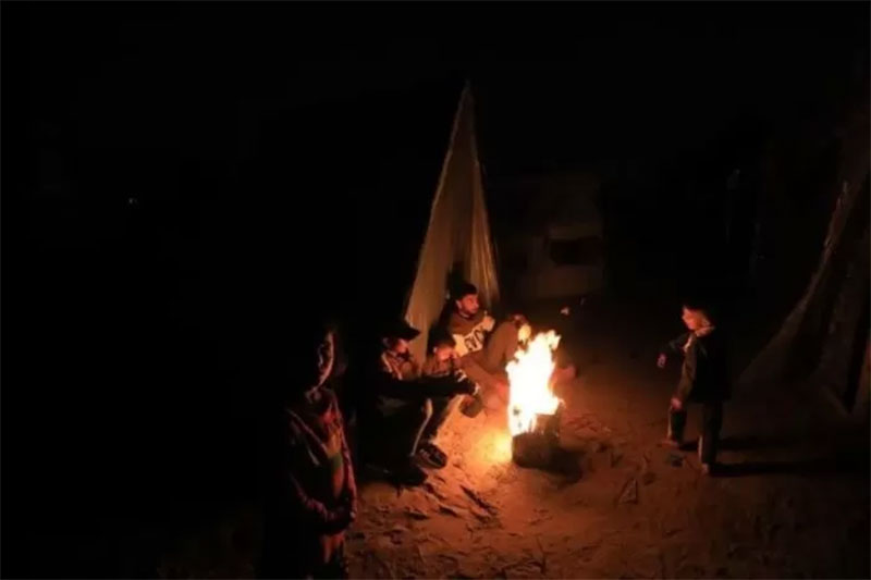 Pengungsi Palestina di tengah api unggun di tempat penampungan sementara di kota Rafah, Jalur Gaza selatan, pada 18 Desember 2023