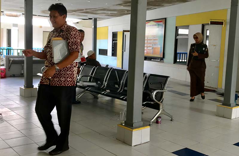 USAI PEMERIKSAAN: Rektor Unri Aras Mulyadi menuju loker untuk mengambil barang bawaan usai keluar dari ruang pemeriksaan  Kejati Riau, Jalan Arifin Achman,  Rabu (3/7/2019).