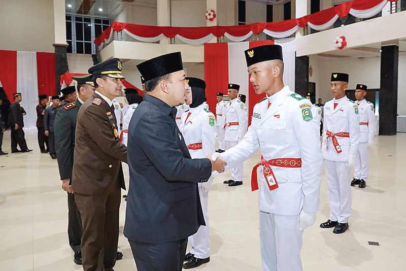 Wabup Siak Husni Merza bersalaman dengan anggota Paskibra usai pengukuhan di Gedung Kesenian Siak,  Rabu (16/8/2023).