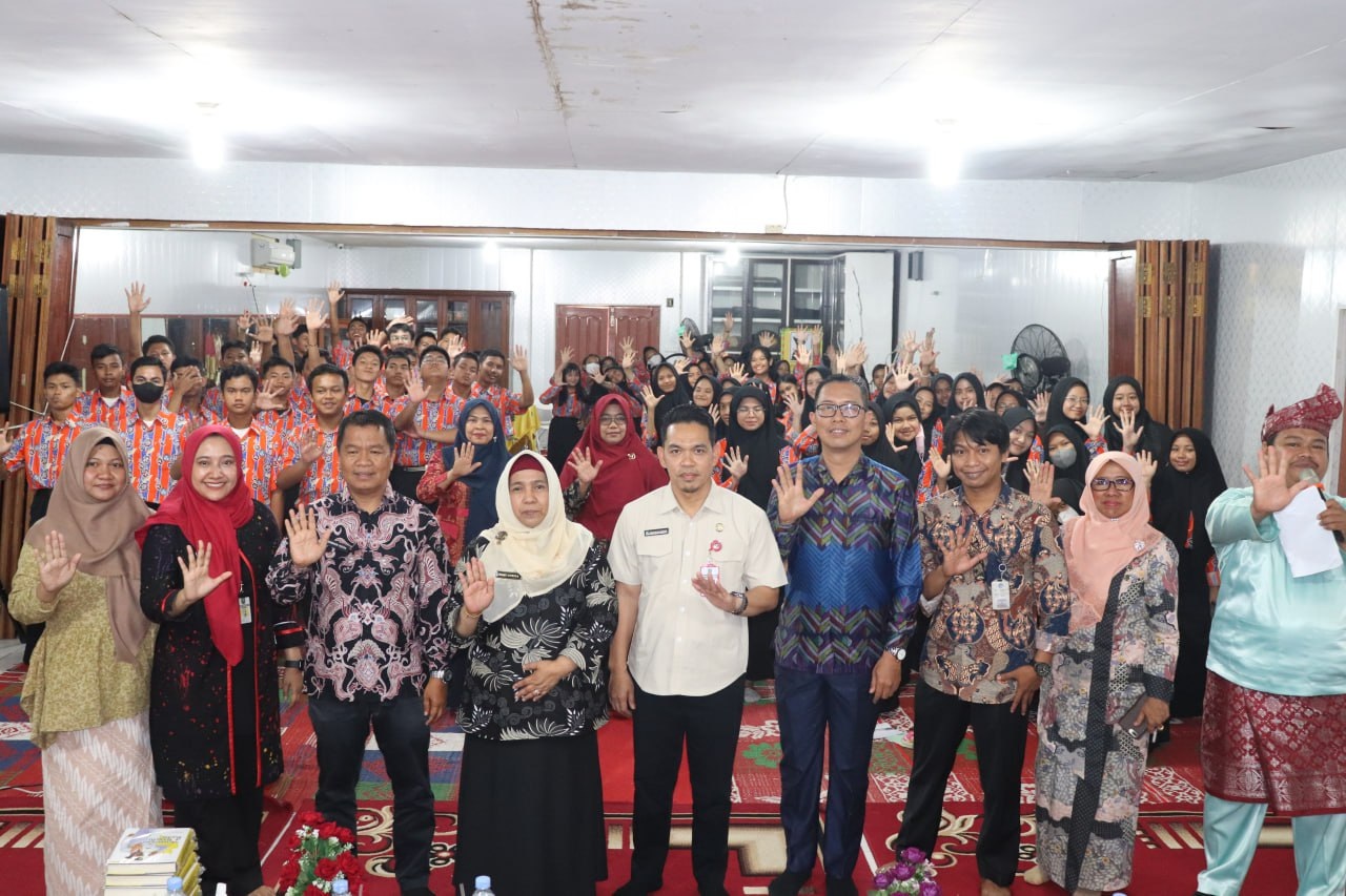 Kadiskominfotik Riau Erisman Yahya foto bersama dengan majelis guru dan siswa SMAN 5 Pekanbaru usai penyampaian literasi media, Kamis (23/2/2023).