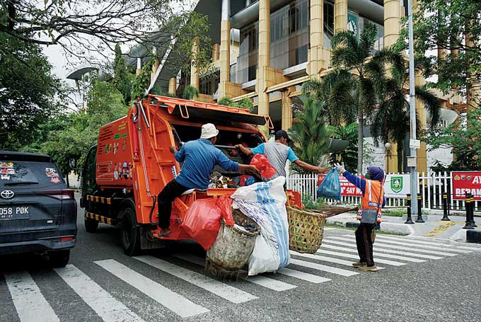 Pekerja mengangkut sampah perkotaan dengan armada terbaru yang lebih efisien milik Pemerintah Kota Pekanbaru, Jumat (23/12/2022).