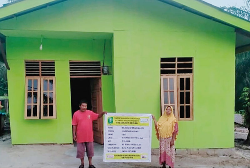 Keluarga penerima bantuan rumah layak huni saat berada di depan rumahnya. Mereka mendapat bantuan rumah ini dari program Desa Bermasa yang dilakukan Pemkab Bengkalis, Rabu (18/10/2023).