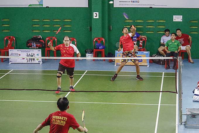 Pasangan ganda putra kategori veteran 95 PB Palma Syaiful/Subhaki saat bertanding menghadapi pasangan PB Tri Jaya Denis/Dirga pada turnamen bulutangkis Riau Pos Tabungan BRI Britama Cup di GOR Ikatan Keluarga Persaudaraan Tionghoa Bengkalis (IKPTB), Jumat
