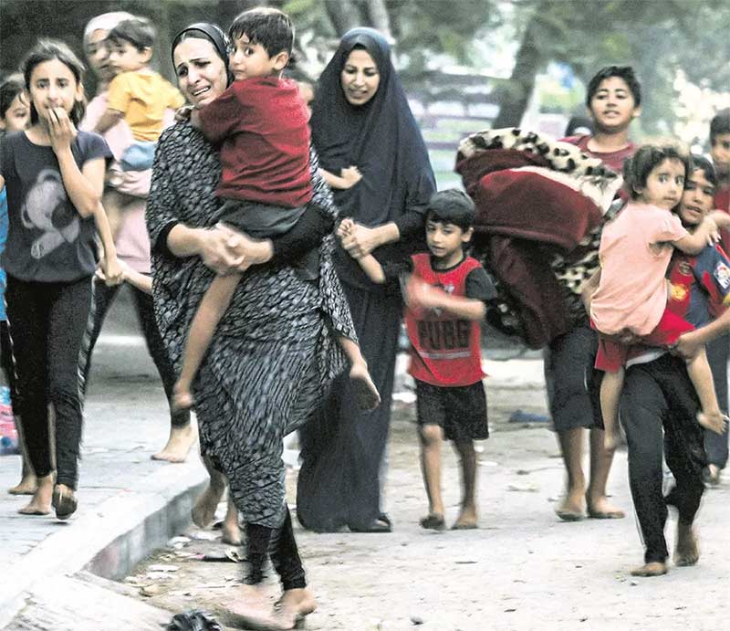 Perempuan dan anak-anak Palestina bergegas meninggalkan rumah ketika militer Israel menggempur Kota Gaza, Rabu (11/10).