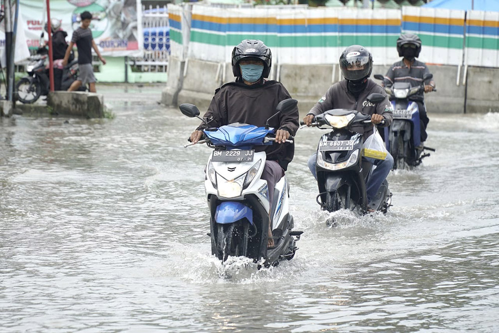 Kendaraan bermotor menerobos genangan air saat melintas di Jalan Ahmad Dahlan, Kota Pekanbaru,  beberapa waktu lalu. Hujan deras yang mengguyur Kota Pekanbaru membuat beberapa titik jalanan tergenang banjir. DEFIZAL /Riau Pos