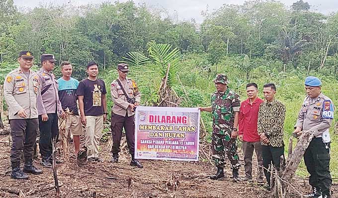 Kapolsek Rambah Samo Ipda Totok Nurdianto SH bersama personel TNI foto bersama, usai memimpin patroli dan sosialisasi dampak karhutla kepada sejumlah petani di Desa Rambah Samo, Ahad (30/4/2023) petang.
