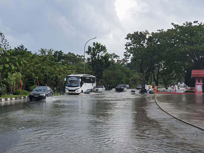 Beberapa kendaraan menerobos banjir yang menggenangi jalan di depan SPBU Arifin Achmad ujung, Pekanbaru, Ahad (6/11/2022).