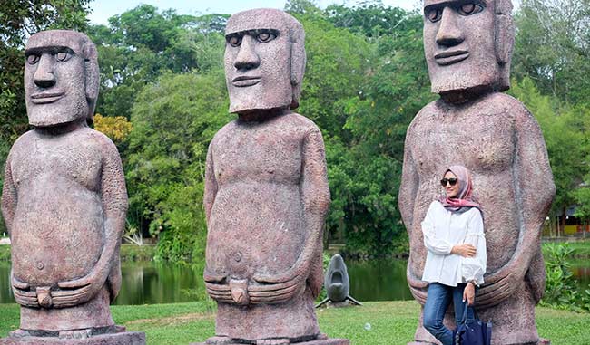 Patung Etnik: Seorang pengunjung  berfoto di patung etnik yang merupakan salah satu tempat favorit untuk berfoto yang berada di Taman Rekreasi Alam Mayang Pekanbaru Selasa (11/9/2018). Amel for Riau Pos