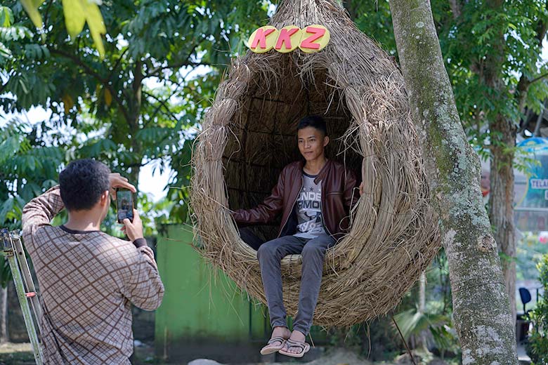 SARANG BURUNG: Pengunjung menikmati suasana sebagai lokasi berfoto di tempat duduk mirip sarang burung di Kebun Binatang Kasang Kulim, Kubang, Sabtu (16/3/2019).